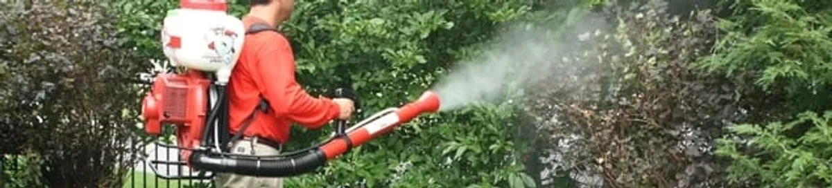 Mosquito control technician fogging shrubs and landscaping for mosquito treatment in Saint Louis, MO
